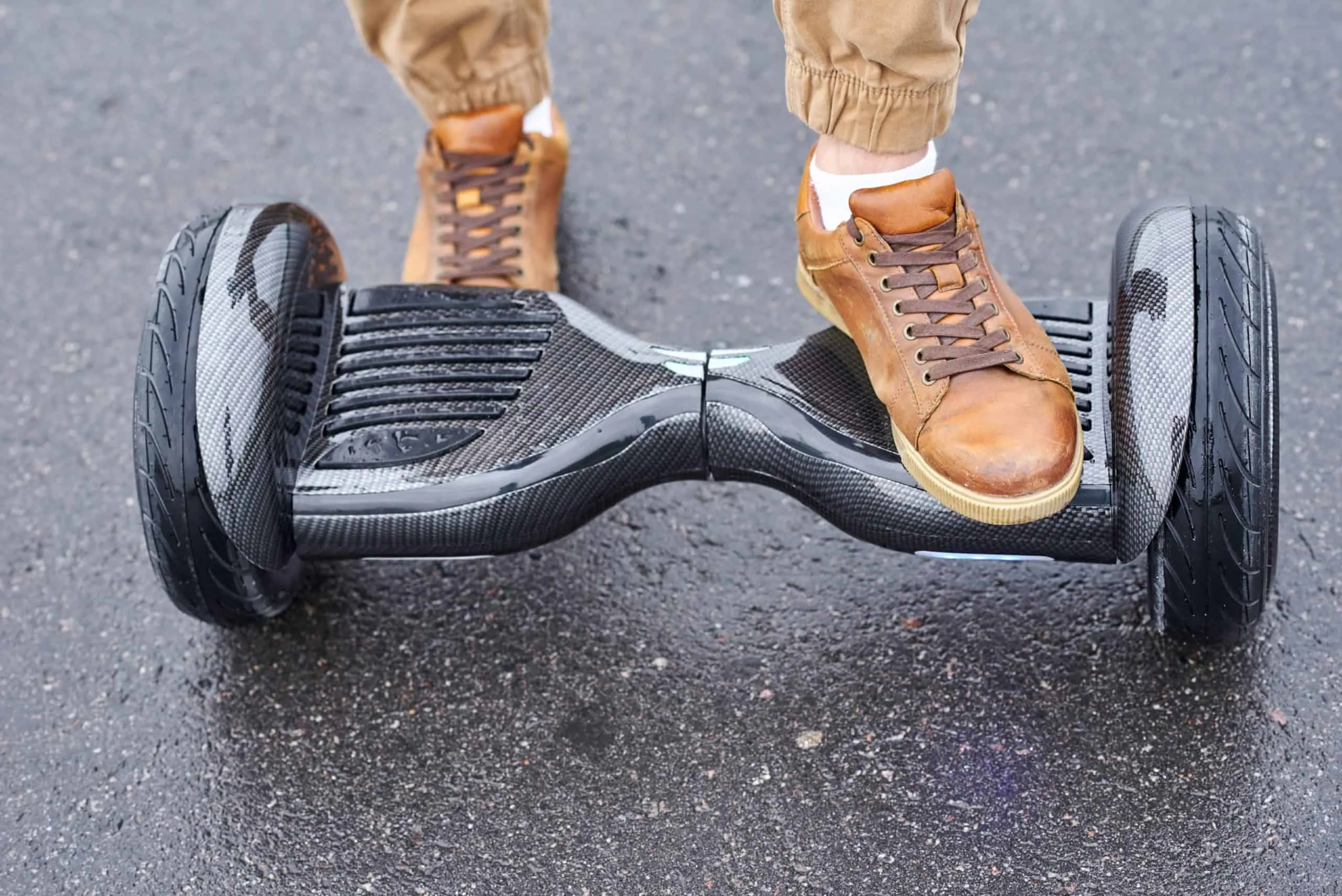 Man using hoverboard on asphalt road