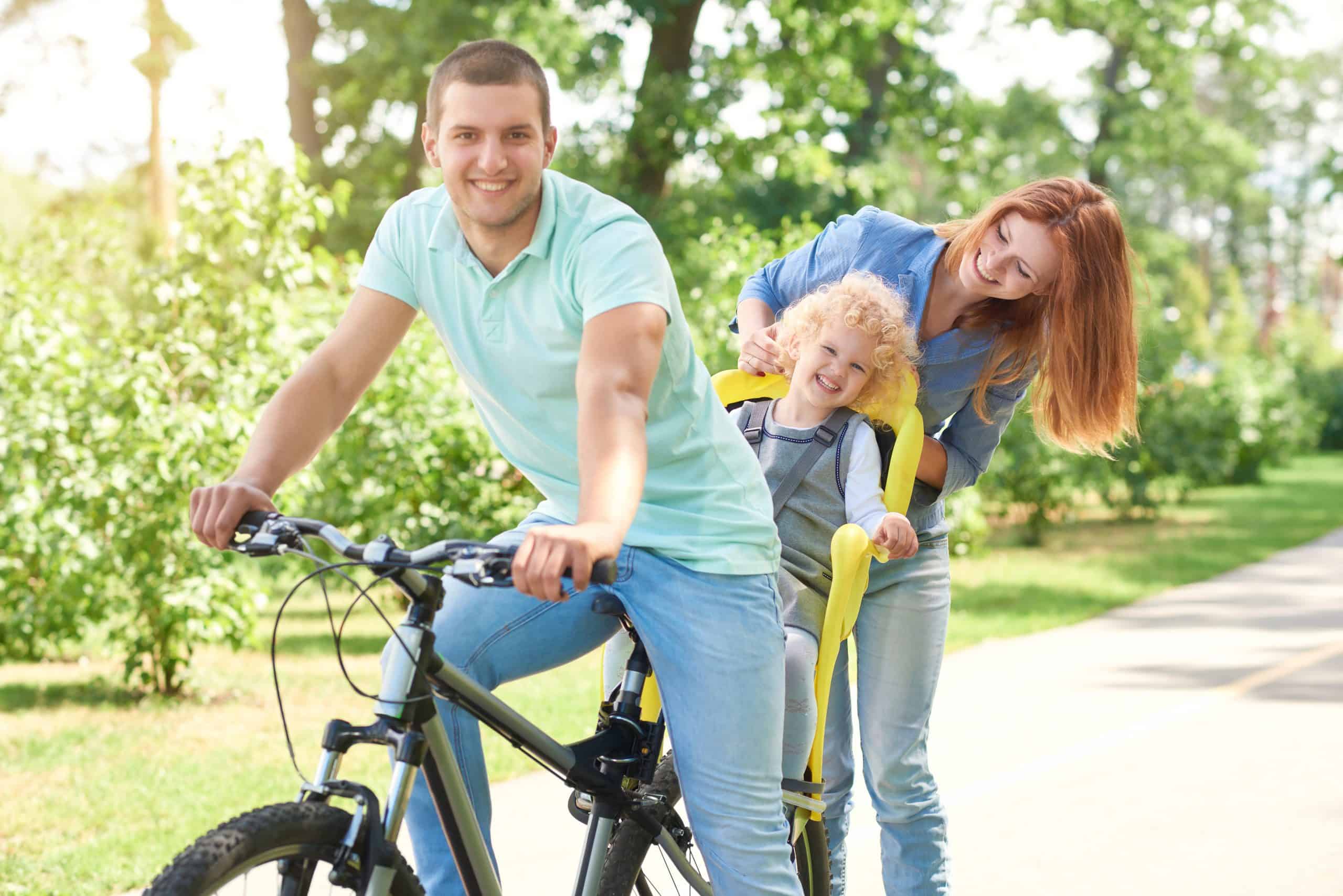 Happy family riding bike at the park Is It Legal To Carry Your Child in a Bike Seat on An Electric Bike?